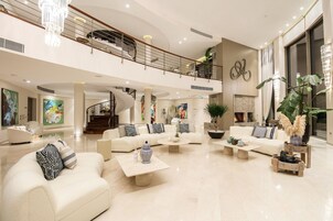 Amplio espacio habitable de varios niveles con muebles modernos, una escalera y una planta grande.