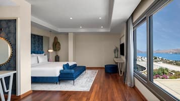 Un dormitorio moderno con una cama grande, un tocador con espejo y vistas al mar.