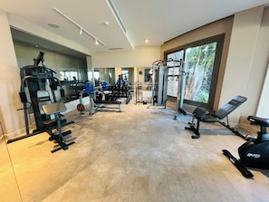 A gym with various exercise equipment, large windows, and a tiled floor. - Ailla Yalıkavak (Bodrum)
