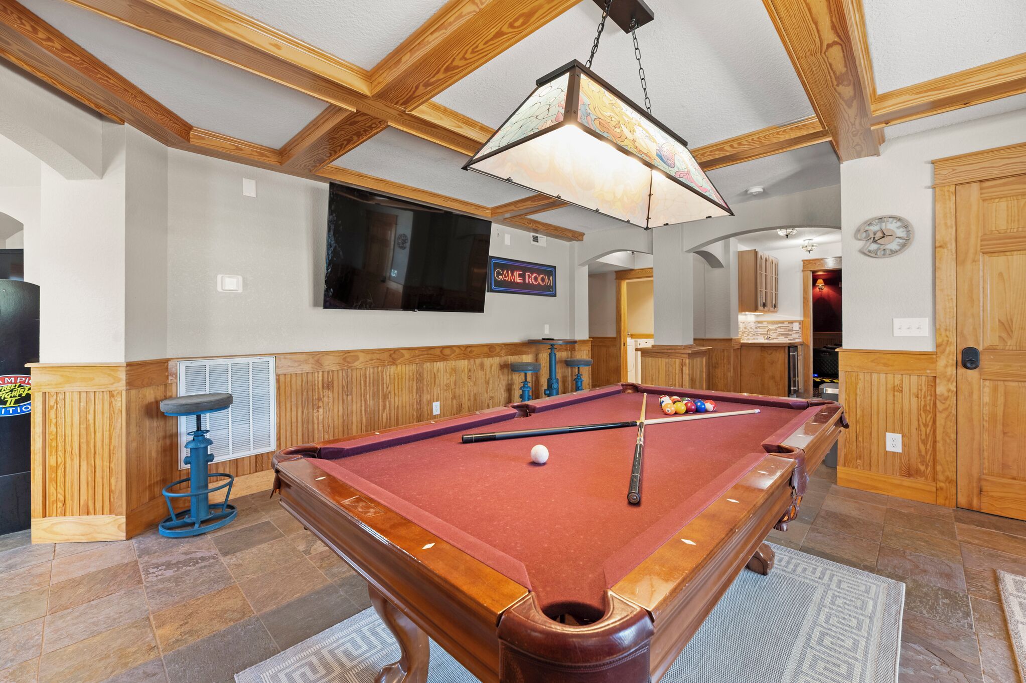Une table de billard recouverte d’un drap de feutre rouge, un queue de billard bleu et une boule blanche.