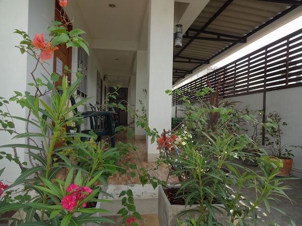 A covered outdoor area with potted plants and a pathway leading to a covered seating area. - Rena House Chiang Mai (Chiang Mai)