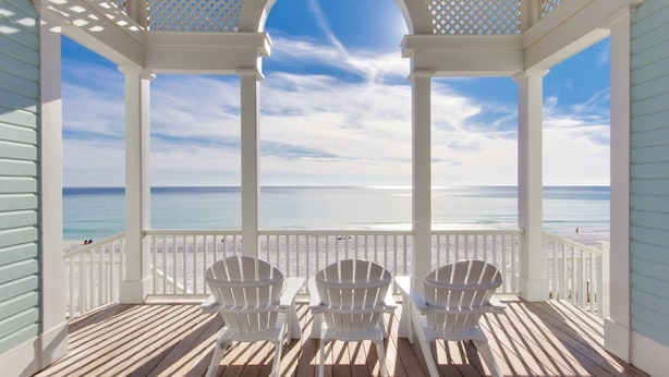 A covered outdoor seating area with white chairs and a view of the beach. - Great Porches! Parking! Walk to Seaside and Beach! (Santa Rosa Beach)
