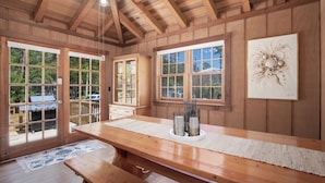 A wooden dining area with a large table, benches, and a view of the outdoors. - Great Porches! Parking! Walk to Seaside and Beach! (Santa Rosa Beach)