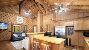 A wooden interior with a kitchen, bar area, and seating. - Great Porches! Parking! Walk to Seaside and Beach! (Santa Rosa Beach)