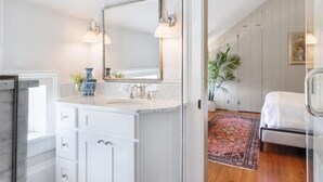 Une salle de bain moderne avec un grand miroir, deux lavabos et un meuble-lavabo blanc.