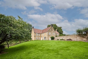 A stone house with a red-tiled roof, a grassy lawn, and a stone wall. - Host & Stay | Stay House (Northallerton)