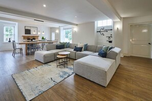 A spacious living room with a sectional sofa, a round coffee table, and a fireplace. - Host & Stay | Stay House (Northallerton)