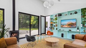 Ein modernes Wohnzimmer mit Kamin, Fernseher und Bücherregal.
