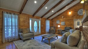 A cozy log cabin interior with a living room featuring a sofa, armchairs, a coffee table, and a fireplace. - Large Cabin Near the town of Blue Ridge! (Blue Ridge)