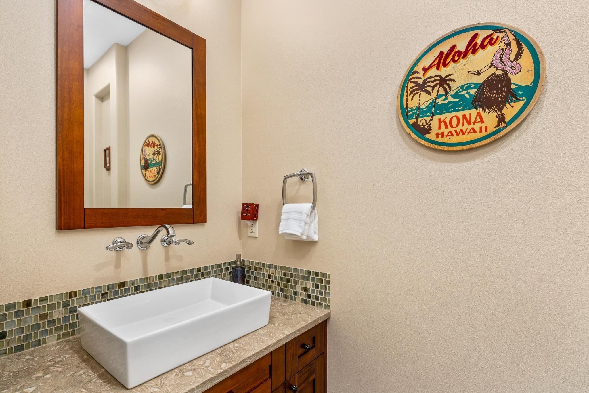 Une salle de bain avec un lavabo blanc, un miroir et un porte-serviettes.