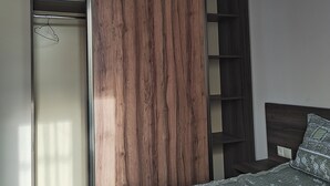 Ein Schlafzimmer mit einem Bett, einem Kleiderschrank und einer Hängeleuchte.