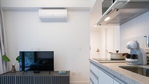 Una cocina moderna con horno empotrado, microondas y cafetera.