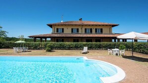 A two-story building with a swimming pool in front.