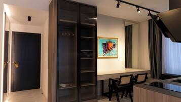 A modern kitchen with a dining area, a sliding glass door closet, and a painting on the wall.