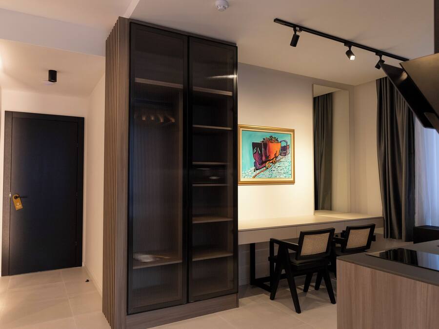 A modern kitchen with a dining area, a sliding glass door closet, and a painting on the wall.