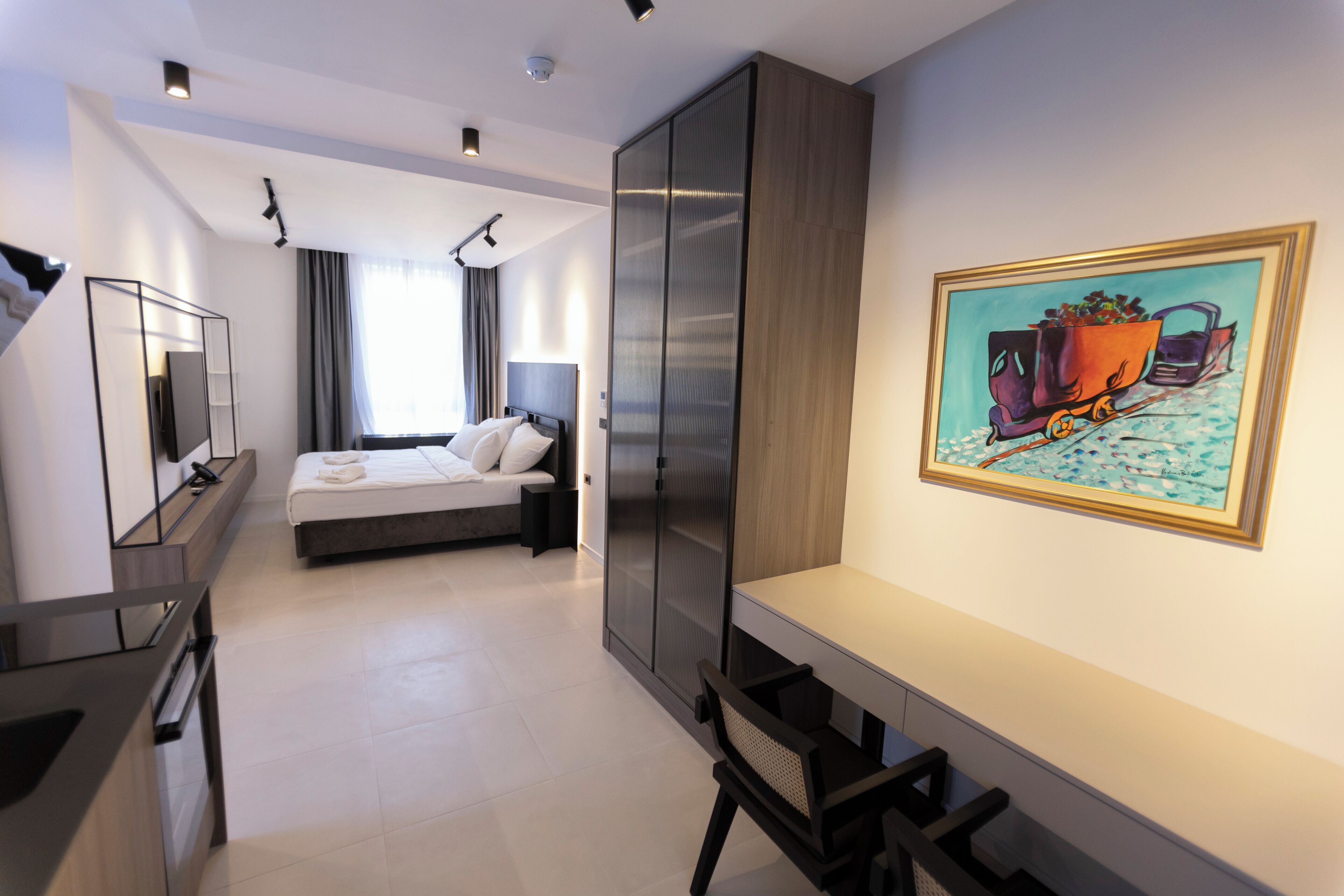 Una habitación de hotel moderna con una cama, una mesita de noche y un cuadro grande en la pared.