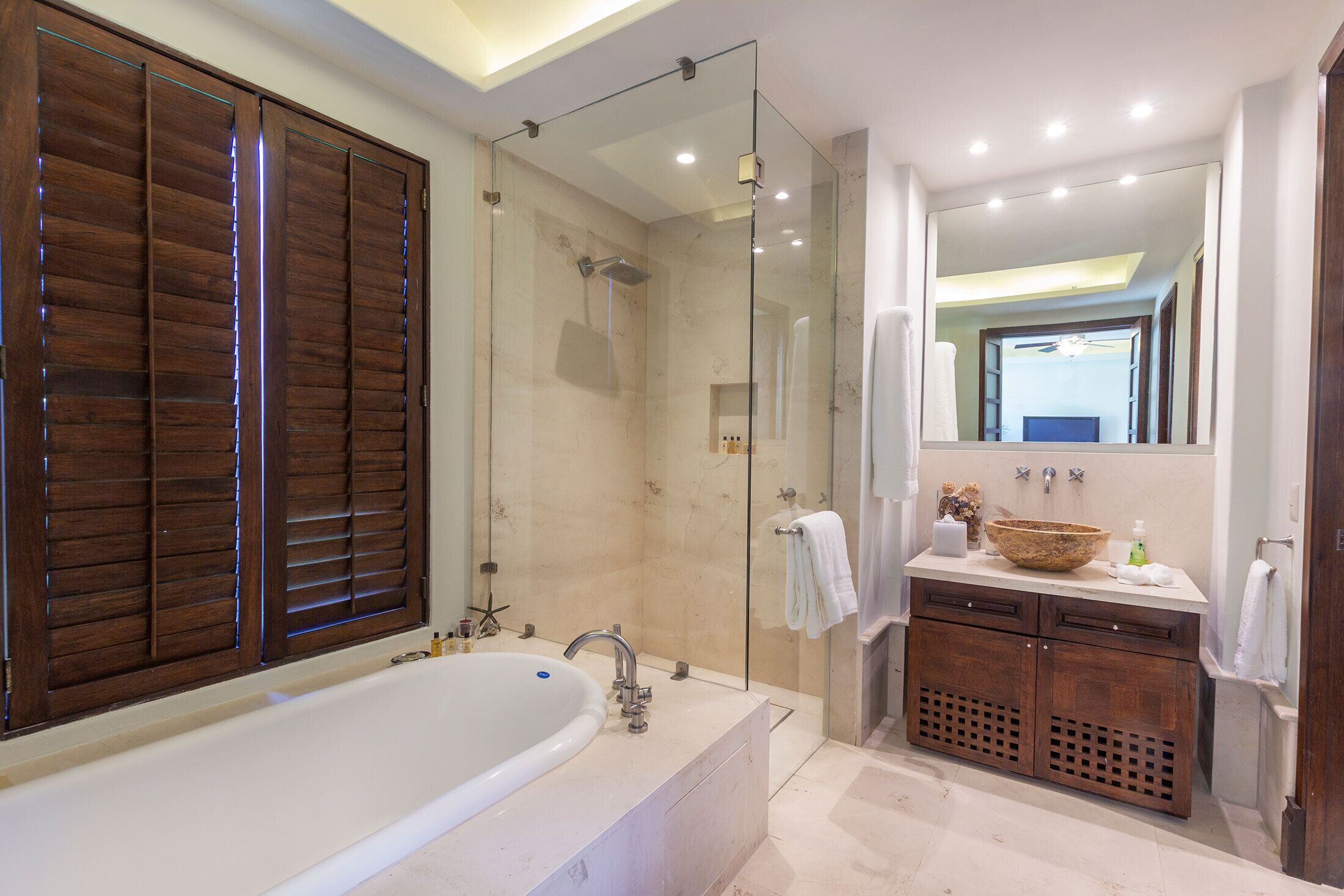 Un baño moderno con una bañera grande, ducha con cerramiento de vidrio y tocador con espejo.