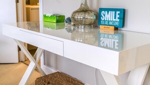 A white desk with a glass top, a decorative vase, a green box, and motivational signs. - Gorgeous Hampstead Flat (London)