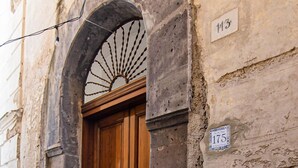 A stone building with a wooden door and a sign indicating the number 113.