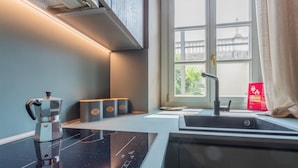 A modern kitchen with a built-in stove, a sink, and a window with a view of greenery. - Lagrange Design Apartments - Beta by Wonderful Italy (Turin)