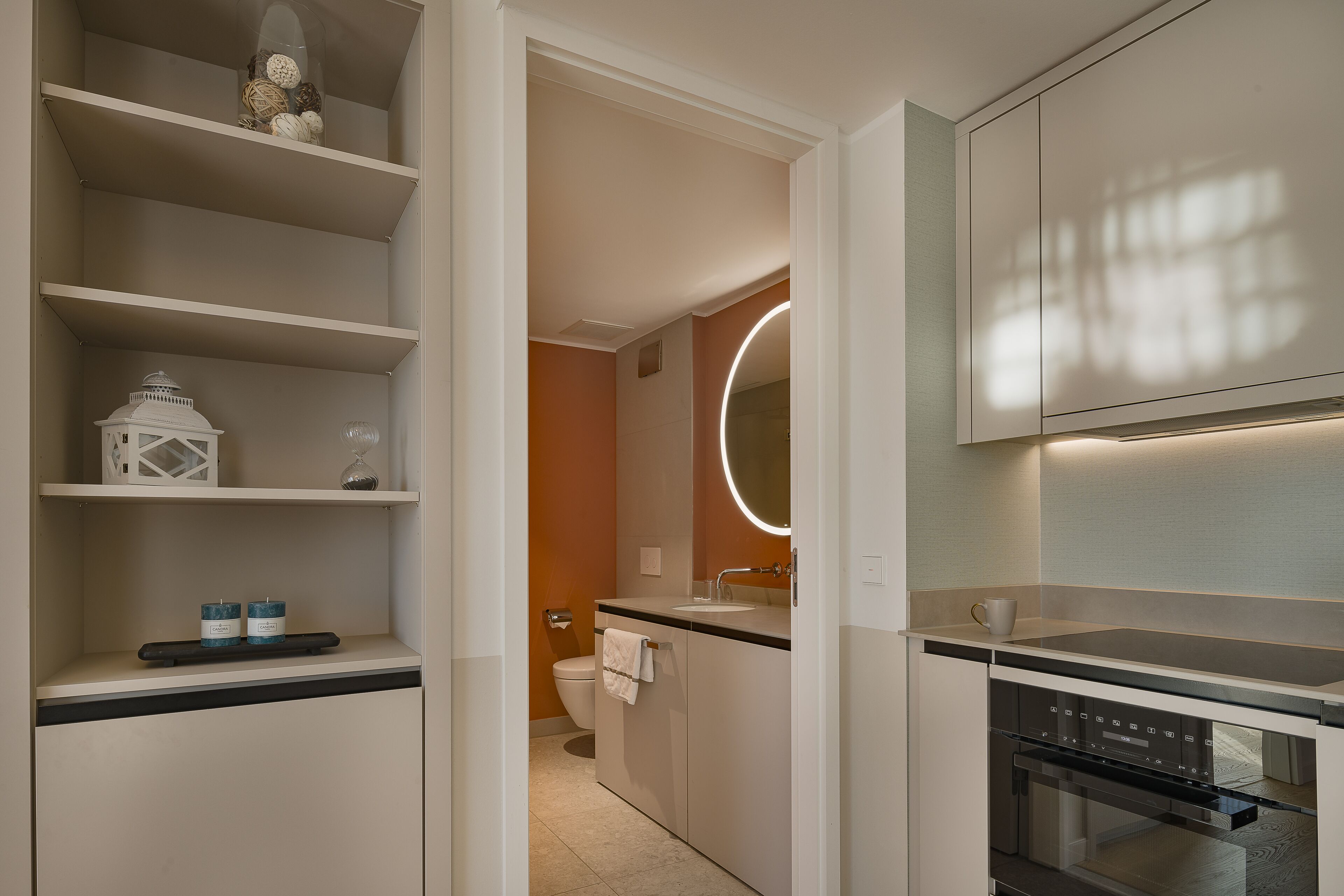 A modern kitchen with built-in appliances, a central island, and a large window.