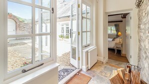 A room with large windows, a stone wall, and a bed with a nightstand. - The Chapel - UK45026 (Crickhowell)