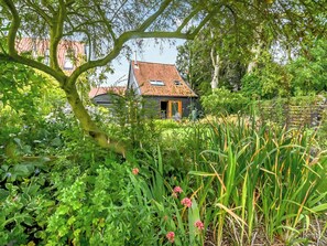Una casa rodeada de abundante vegetación y un jardín.