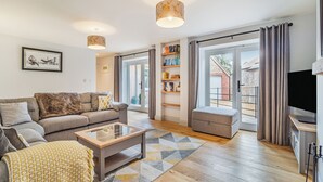 Un salon moderne avec un canapé, une table basse et un téléviseur.
