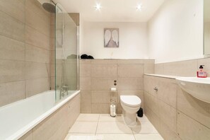 A modern bathroom with a glass shower enclosure, a toilet, and a sink. - Immaculate 1-bed Apartment in London - Mydas Place (London)