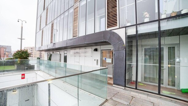 A modern building with a glass facade, a covered outdoor area, and a visible entrance labeled "PEYS COURT".