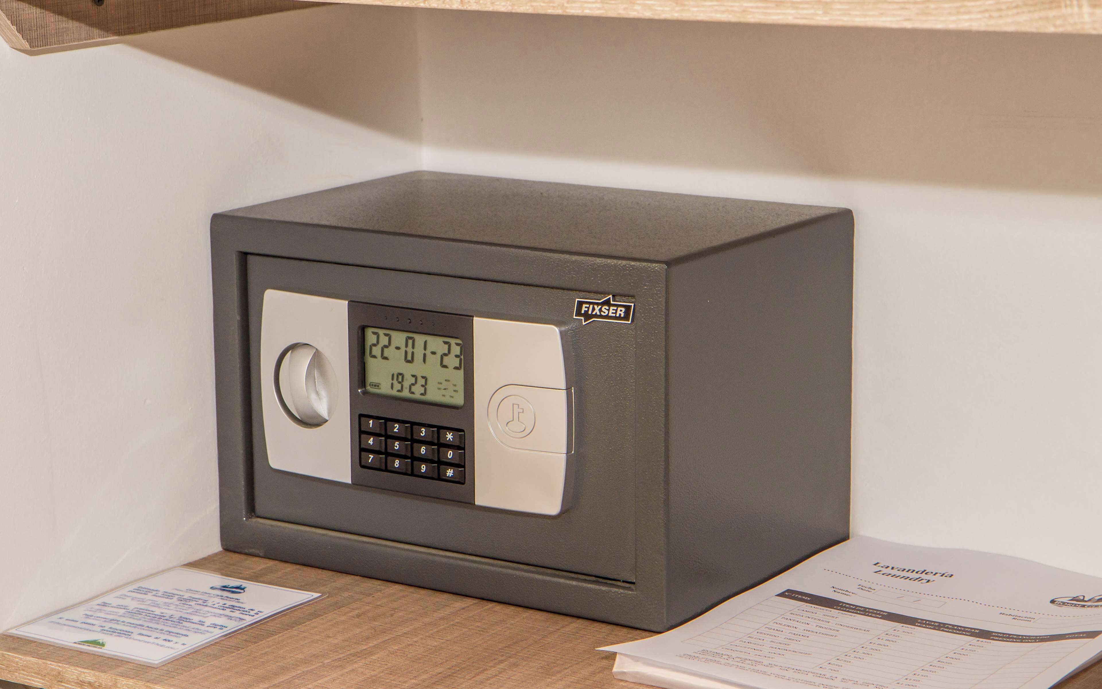 Un portaforti grigio con display digitale che mostra data e ora, una tastierino numerico e una serratura.
