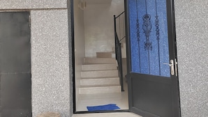 Een gebouw-ingang met een trap die naar een verdieping leidt.