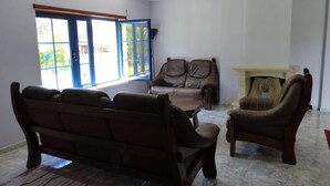 Un salon avec un canapé, un fauteuil et une petite table.