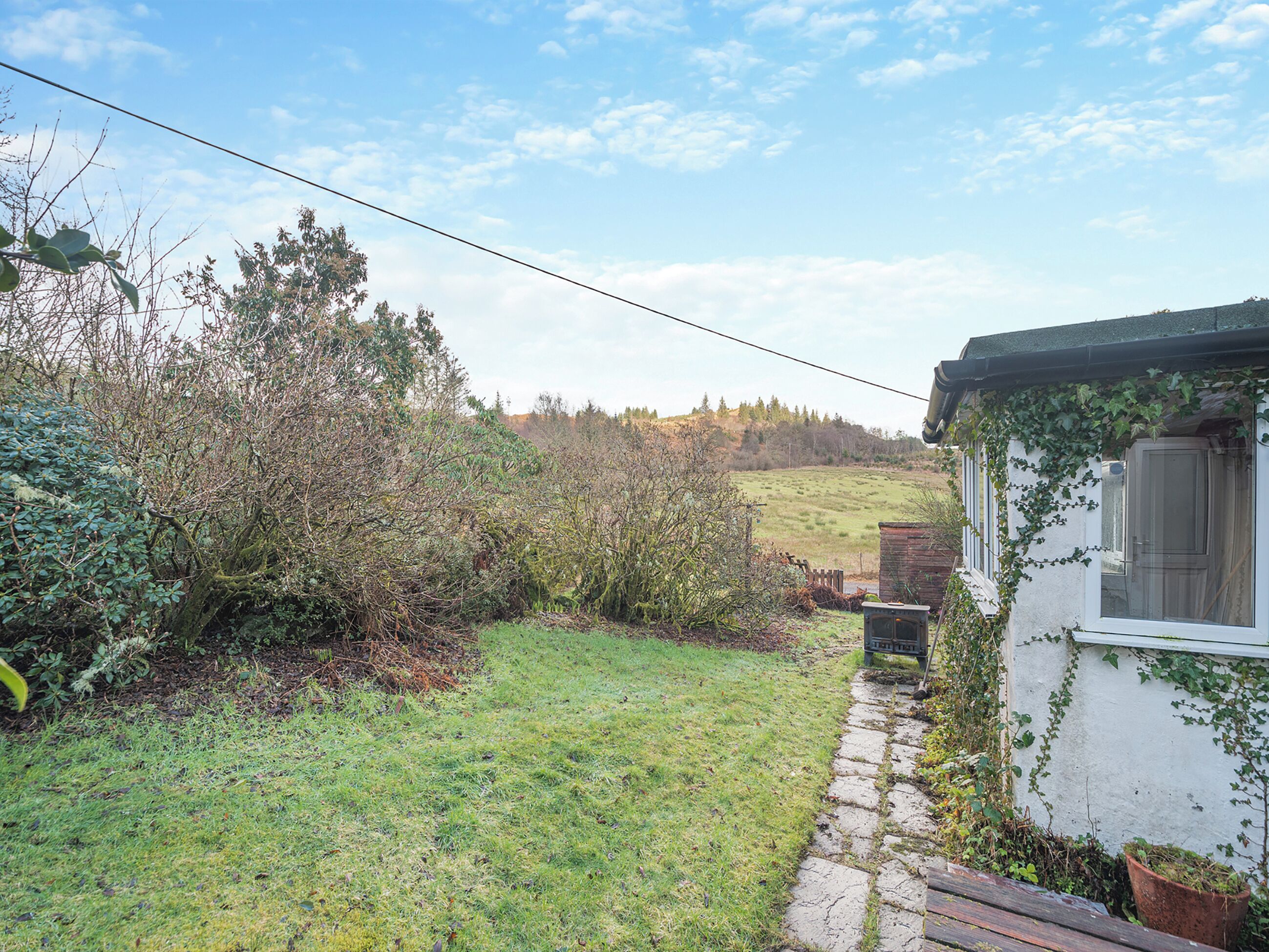 Une maison de campagne rustique, avec un chemin de pierres menant à une porte en bois.