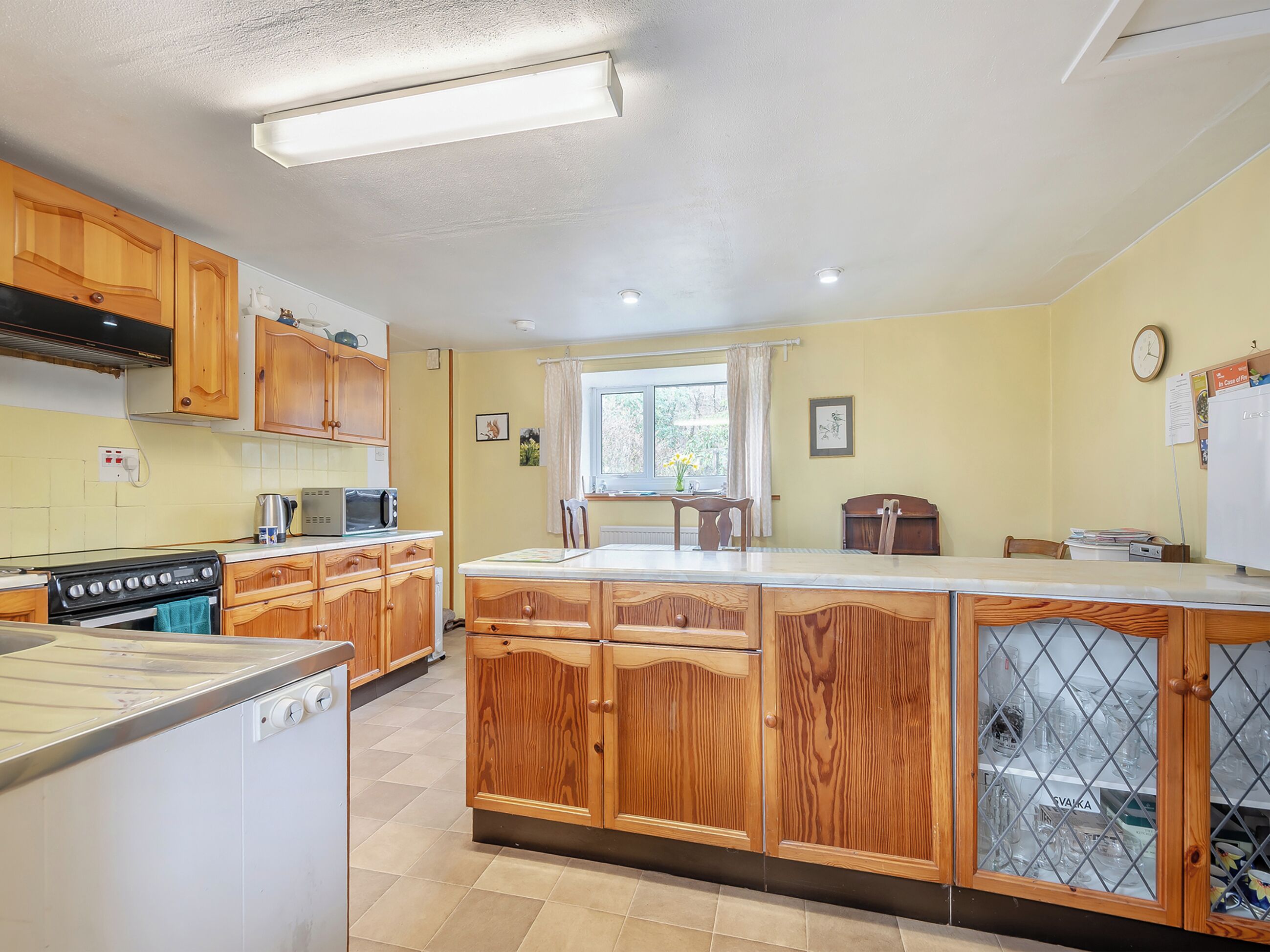 Una cocina con armarios de madera, una estufa y un refrigerador.