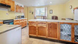 Eine Küche mit Holzschränken, einem Herd und einem Kühlschrank.