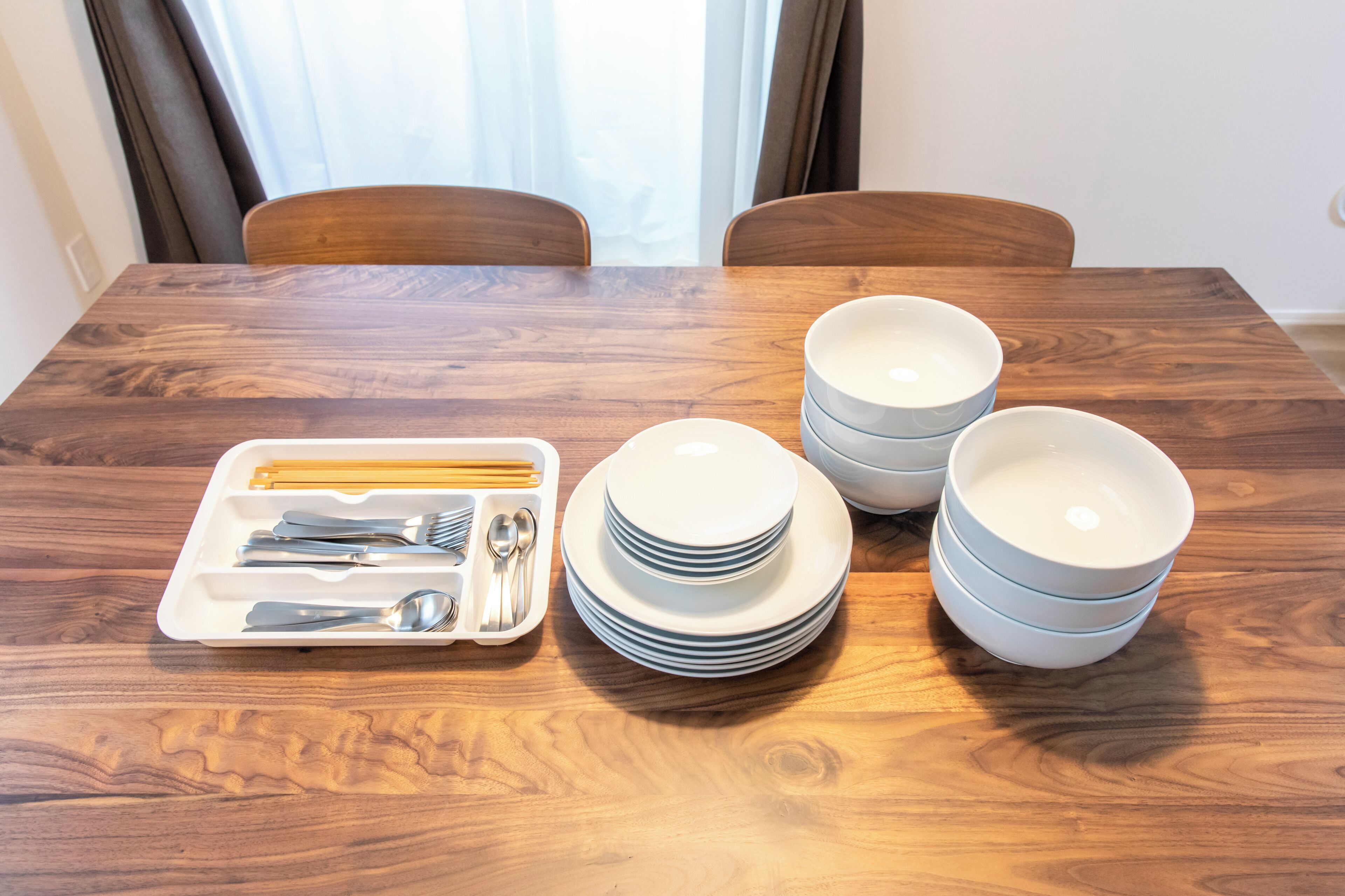 Une table à manger avec un ensemble d’assiettes, de bols et de couverts.