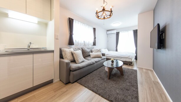 Una sala de estar moderna con un sofá, una mesa de centro y un televisor montado en la pared.