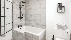 A modern bathroom with a corner shower, a freestanding bathtub, and a toilet. - 2 bedroom accommodation in Blackpool (Blackpool)