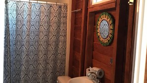 Une salle de bain équipée de toilettes, d’un lavabo et d’un miroir décoratif.