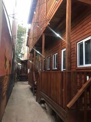 A narrow wooden building with multiple windows and a staircase leading to an upper level. - Cabanas Chac Mool (Isla Holbox)