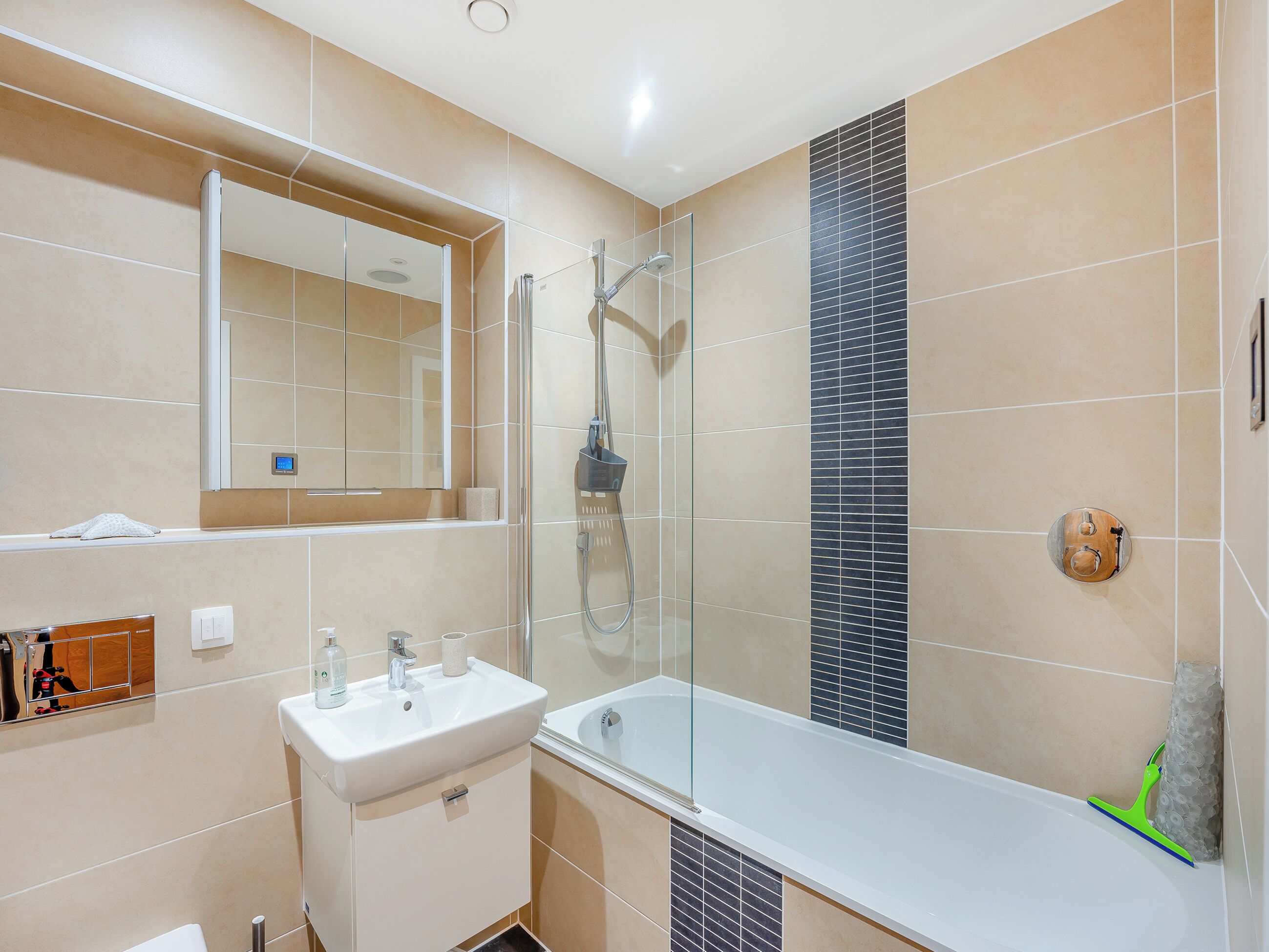 Un baño moderno con ducha de vidrio, lavamanos blanco y bañera.