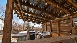 Ein Außenbereich mit Küche, Grill, Spüle und einer Holzterrasse.