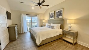 A bedroom with a bed, nightstands, a ceiling fan, and artwork on the wall. - Enjoy The Ocean Breeze just Steps from the Beach! (Corolla)