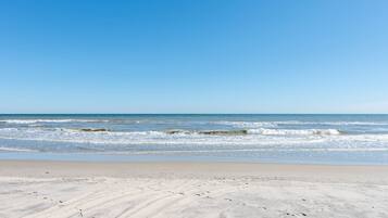 A beach with waves and a clear sky.