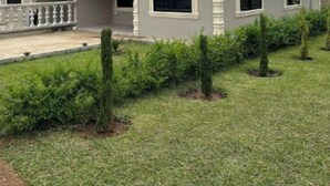 A two-story house with a red roof, a balcony, and a well-maintained lawn with small trees. - Grace’s Cozy Place Unit A in Makeni, Lusaka (Lusaka)