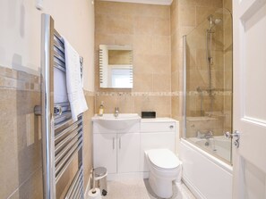 A modern bathroom with a toilet, sink, and shower. - Sublyme (Lyme Regis)