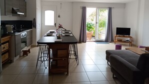 Una cocina moderna con comedor, sofá y televisor en la sala.