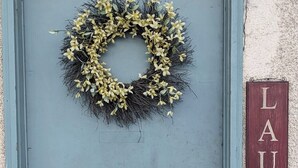 A door with a wreath and a sign reading "LAUNDRY".