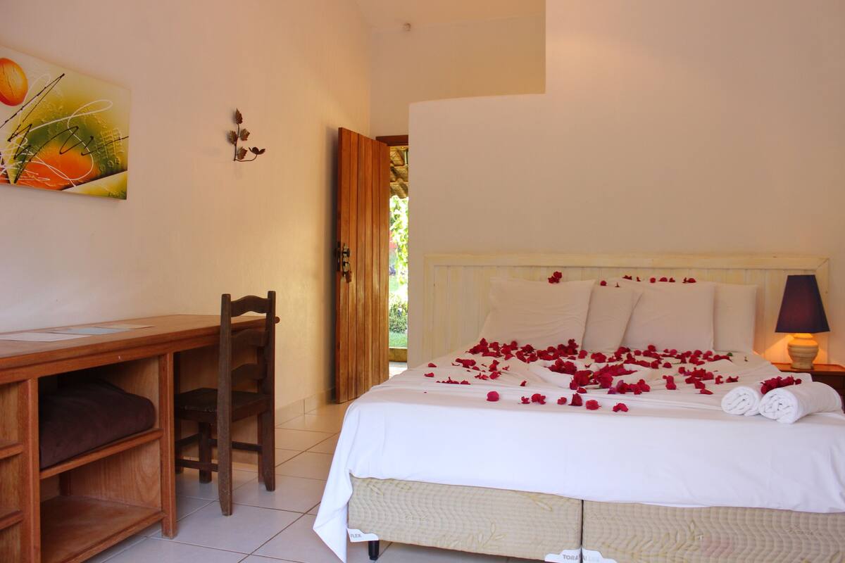A bedroom with a bed, a desk, and a chair.